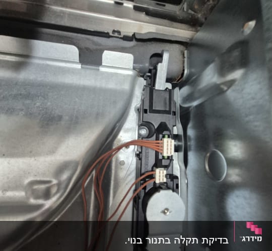 חוטים מחוברים לרכיב חשמלי בתוך מכשיר מתכתי